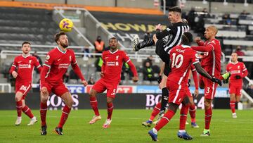 NEWCASTLE UPON TYNE, ENGLAND - DECEMBER 30: Ciaran Clark of Newcastle United wins a header under pressure from Fabinho and Sadio Mane of Liverpool during the Premier League match between Newcastle United and Liverpool at St. James' Park on December 3