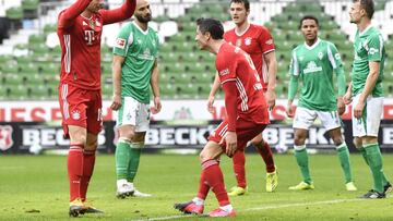 Bayern's Robert Lewandowski, center, celebrates with Leon Goretzka, left, after scoring his side's third goal during the German Bundesliga soccer match between Werder Bremen and Bayern Munich in Bremen, Germany, Saturday, March 13, 2021. (AP Pho