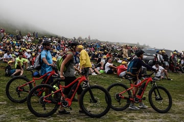 Los aficionados poblando a la ladera de la montaña brumosa para ver la carrera de bicicletas.