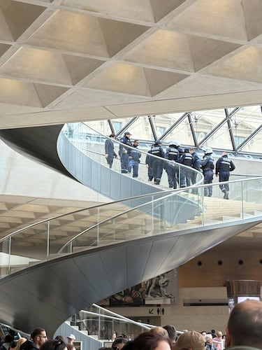 La policía se reúne en la escalera de caracol de la Pirámide del Louvre tras el robo de piezas de joyería de la colección de Napoleón en el museo.