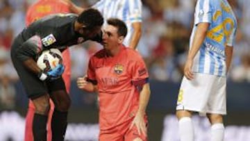 El portero camerunés del Málaga Carlos Kameni atiende al delantero argentino Leo Messi tras un lance de juego en La Rosaleda.
