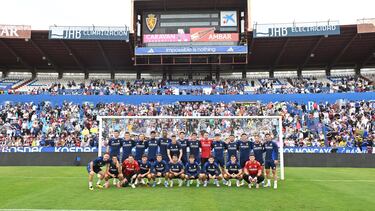 Foto de familia de los jugadores con la afición al fondo.