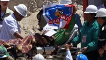 Uno de los mineros chilenos sale de la cápsula con la bandera de Colo Colo