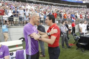 Coaches Zinedine Zidane and Unai Emery greet each other before the match.