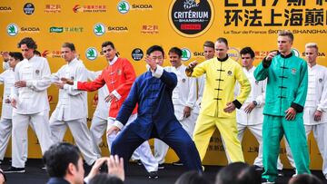 A martial arts master (C) leads riders in the Tour de France China Criterium including Warren Baguil of France (in red), Chris Froome of Britain (in yellow), and Marcel Kittel of Germany (green) in a tai chi routine at a pre-race launch event in Shanghaix92s financial district on October 28, 2017.
 Riders will compete on October 29 in the first-ever China Criterium, part of the Tour de Francex92s efforts to further popularise the historic French race in Asia. / AFP PHOTO / STR / China OUT