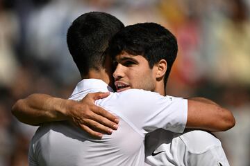 Carlos Alcaraz es abrazado por Novak Djokovic, que le felicita por su triunfo en la final de Wimbledon 2024.