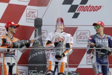 El campeón del mundo de Moto GP, el piloto español Marc Márquez, celebra su título al terminar tercero en la última prueba del mundial el Gran Premio de la Comunidad Valenciana disputado en el Circuito Ricardo Tormo en Cheste junto a Jorge Lorenzo y Pedrosa en el podio