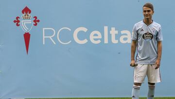 Denis Su&aacute;rez posa delante del escudo del Celta durante su presentaci&oacute;n en Bala&iacute;dos.