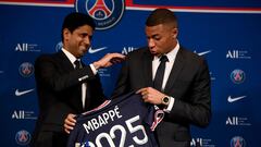 Paris Saint-Germain's CEO Nasser Al-Khelaifi (L) and French forward Kylian Mbappe (R) pose with a jersey at the end of a press conference at the Parc des Princes stadium in Paris on May 23, 2022, two days after the club won the Ligue 1 title for a record-equalling tenth time and its superstar striker Mbappe chose to sign a new contract until 2025 at PSG rather than join Real Madrid. (Photo by FRANCK FIFE / AFP) 
PUBLICADA 24/05/21 NA MA03 1COL