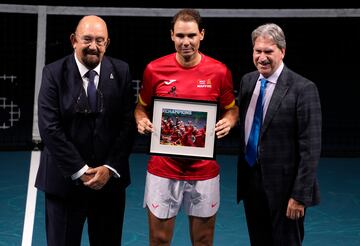 Rafa Nadal posa junto al presidente de la Federación Española de Tenis, Miguel Díaz (izq.), y el presidente de la Federación Internacional de Tenis, David Haggerty (der.), durante un homenaje a su carrera al final del partido de dobles de cuartos de final entre Holanda y España durante la Copa Davis en el Palacio de Deportes José María Martín Carpena en Málaga.
