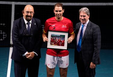 Rafa Nadal posa junto al presidente de la Federación Española de Tenis, Miguel Díaz (izq.), y el presidente de la Federación Internacional de Tenis, David Haggerty (der.), durante un homenaje a su carrera al final del partido de dobles de cuartos de final entre Holanda y España durante la Copa Davis en el Palacio de Deportes José María Martín Carpena en Málaga.
