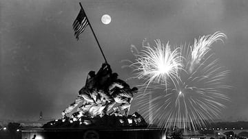 FILE - In this July 4, 1966 file photo, the moon shines above the United States Marine Corps War Memorial, which depicts a scene from Iwo Jima, as fireworks burst over Washington, seen from the Virginia side of the Potomac River. The Washington Monument a