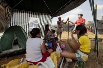 Una familia permanece en una vivienda improvisada en una área particular que fue ocupada por Integrantes del Movimiento de los Trabajadores Sin Techo (MTST) en un área que fue ocupada el pasado sábado situada a unos 4 kilómetros del estadio Arena Corinthians de Sao Paulo, una de las doce sedes del Mundial Brasil 2014 y que recibirá seis partidos del evento deportivo, entre ellos el inaugural del 12 de junio. De acuerdo con el movimiento, las familias que ocuparon el terreno, abandonado desde hace más de 20 años, vivían en áreas "de riesgo", "en favelas o sin condiciones para pagar el alquiler por culpa de la especulación inmobiliaria en la región, resultado de la construcción del estadio de apertura del Mundial".