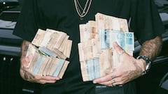 El surfista Pedro Scooby sostiene fajos de billetes de 50 y 100 reales brasile&ntilde;os en un videoclip de L7nnon. 