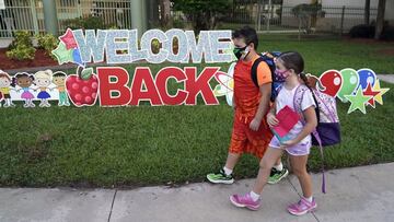 ARCHIVO - En esta foto de archivo del martes 10 de agosto de 2021, estudiantes con m&aacute;scaras protectoras pasan frente a un letrero de &quot;Bienvenida de regreso&quot; antes del primer d&iacute;a de clases en la escuela primaria Sessums en Riverview, Florida. 