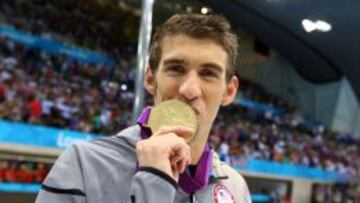 El estadounidense Michael Phelps besa en Londres su medalla olímpica de 4x100 estilos.