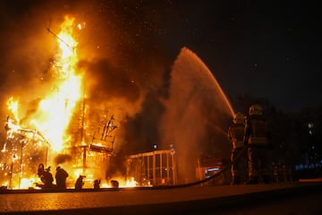 Dos bomberos apagan la Crem de la Falla del Ayuntamiento.