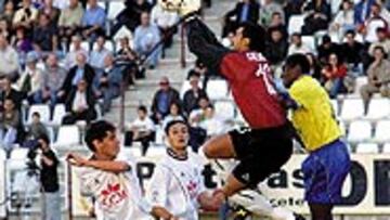 <b>YA ESTÁ ARRIBA</b>. El meta del Albacete Roa despeja el balón ante el acoso de un jugador de Las Palmas.