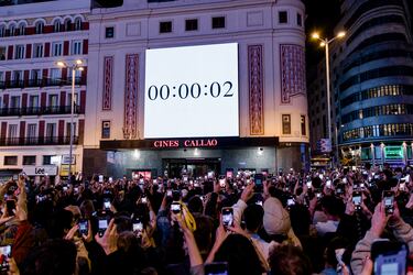 Decenas de personas observan la portada del nuevo álbum de Rosalía, 'Lux', en la plaza de Callao.