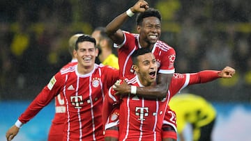 Bayern's David Alaba (up) celebrates with teammates after scoring the 3-0 lead during the German Bundesliga soccer match between Borrusia Dortmund and FC Bayern Munich in Dortmund,