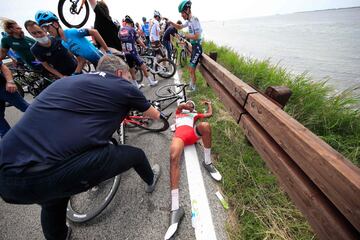 Natnael Berhane permanece tendido en el suedo después de una caída masiva del pelotón durante la 15ª etapa del Giro de Italia 2021, una carrera de 147 km entre Grado y Goriziav