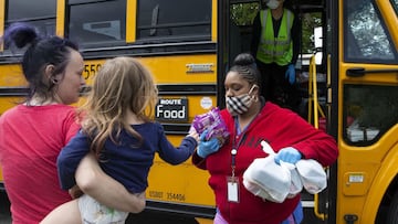 (FILES) In this file photo taken on May 6, 2020, bus driver Treva White and nutritionist ShauntxE9 Fields deliver meals to children and their families in Seattle, Washington. - Child tax credit payments pushed by President Joe Biden to alleviate hardship
