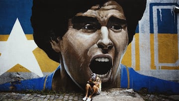 Una seguidora de Diego Armando Maradona llora su muerte delante de un graffiti suyo. 