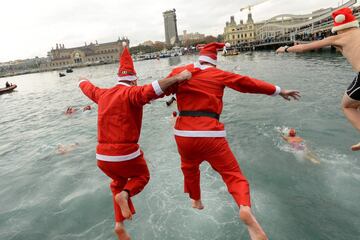Participants in a Santa Claus suits jump into the water during the 108th edition of the 'Copa Nadal' (Christmas Cup) swimming competition in Barcelona's Port Vell on December 25, 2017.  
The traditional 200-meter Christmas swimming race gathered more than 300 participants on Barcelona's old harbour.   / AFP PHOTO / Josep LAGO