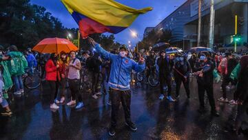 A person waves a national flag during a protest against a proposed government tax reform outside Colombian President Ivan Duque&#039;s house in Bogota, Colombia, on May 3, 2021. - Protesters in Colombia on May 3 called for a new mass rally after 19 people died and more than 800 were wounded in clashes during five days of demonstrations against a proposed government tax reform. Faced with the unrest, the government of President Ivan Duque on May 2 ordered the tax reform proposal be withdrawn from Congress, where it was being debated. (Photo by Juan BARRETO / AFP)