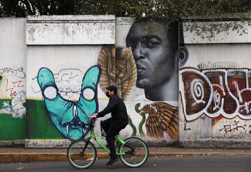 El país donde consiguió su tercer mundial también homenajeó al astro brasileño. En la imagen un hombre en bicicleta pasa delante del mural donde sale dibujado Pelé besando el trofeo de campeón del mundo en 1970.