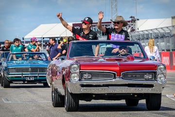 El piloto del equipo Alfa Romeo F1 Zhou Guanyu (izquierda)  y el piloto Valtteri Bottas (derecha) con su peculiar atuendo, en un Pontiac GTO antiguo durante el desfile de piltos, previo al GP de Estados Unidos.