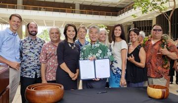 Surfrider posando con el Gobernador de Hawái con la ley que prohibirá los protectores solares en el archipiélago del Pacífico.