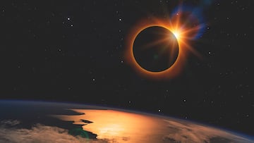 Solar eclipse with orange halo over the planet Earth, on dark starry sky