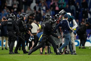 La policía carga contra los aficionados que han invadido el campo al término del derbi catalán.