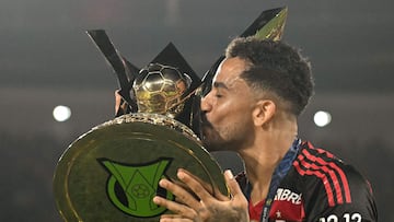 Flamengo's defender #13 Danilo kisses the Brasileirao trophy after winning the Brasileirao Serie A football match between Flamengo and Ceara at Maracana Stadium in Rio de Janeiro, Brazil, on December 3, 2025. (Photo by Mauro PIMENTEL / AFP)
