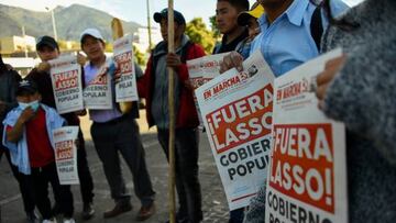 Indigenous people hold signs reading Lasso out!, referring to Ecuadorean President Guillermo Lasso, reproducing the front page of a university weekly newspaper, outside the Central University of Ecuador, where they are taking shelter, in Quito on June 23, 2022, in the framework of indigenous-led protests against the government. - Indigenous Ecuadorans have poured into the capital Quito from across the country in recent days to join protests against high fuel prices and the cost of living. (Photo by Rodrigo BUENDIA / AFP) (Photo by RODRIGO BUENDIA/AFP via Getty Images)