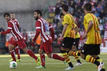 El centrocampista turco del Atlético de Madrid Arda Turan (2i) conduce el balón ante varios jugadores del Sant Andreu durante el partido de ida de los dieciseisavos de final de la Copa del Rey, disputado esta tarde en el estadio Nacís Sala de Barcelona.