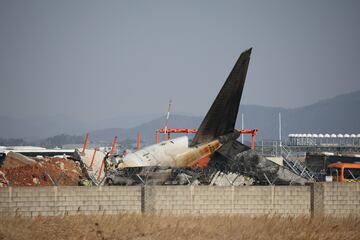 Los restos del avión yacen en el suelo después de que se saliera de la pista y se estrellara en el Aeropuerto Internacional de Muan en Corea del Sur