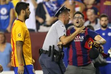Un guarda de seguridad retiene a un aficionado ante la presencia de Luis Suárez.