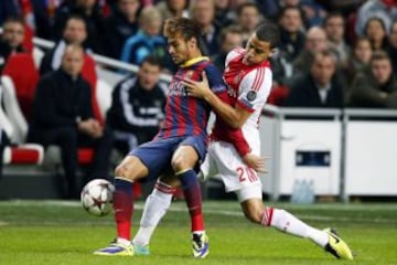 El delantero brasileño del FC Barcelona, Neymar (i) portege el balón ante la presencia de Ricardo van Rhijn (d) del Ajax de Amsterdam durante el partido correspondiente a la fase de grupos de la Liga de Campeones disputado en el Amsterdam Arena