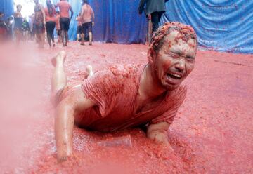 A reveller lies in tomato pulp during the annual Tomatina festival in Bunol near Valencia, Spain, August 30, 2017. REUTERS/Heino Kalis