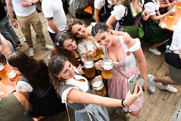 Visitors take a selfie with their beer mugs during the official opening day of the 190th Oktoberfest, the world's largest beer festival in Munich, Germany, September 20, 2025. REUTERS/Angelika Warmuth