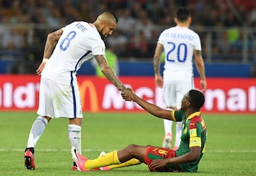 Chile's midfielder Arturo Vidal (L) helps Cameroon's forward Benjamin Moukandjo stand up after a fall during the 2017 Confederations Cup group B football match between Cameroon and Chile at the Spartak Stadium in Moscow on June 18, 2017. / AFP PHOTO / Yuri KADOBNOV