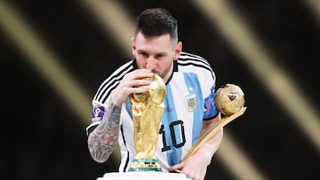 LUSAIL CITY, QATAR - DECEMBER 18: Lionel Messi of Argentina kisses the FIFA World Cup Qatar 2022 Winners' Trophy while holding the adidas Golden Boot award after the FIFA World Cup Qatar 2022 Final match between Argentina and France at Lusail Stadium on December 18, 2022 in Lusail City, Qatar. (Photo by Julian Finney/Getty Images)