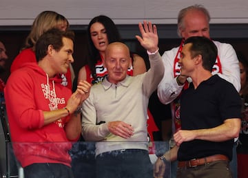Los actores y propietarios del Wrexham, Rob McElhenney y Ryan Reynolds, junto al exfutbolista del Wrexham Mickey Thomas, celebran su ascenso al Championship.