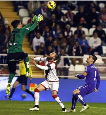 El portero del Rayo Vallecano Álvarez se dispone a detener un balón ante su compañero Tito y el delantero del Espanyol Sergio García, durante el partido de Liga en Primera División que están disputando esta noche en el estadio de Vallecas, en Madrid.