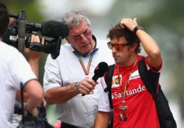 Fernando Alonso con Gary Anderson a su llegada al paddock antes de la sesión de Clasificación del GP de Malaisia.