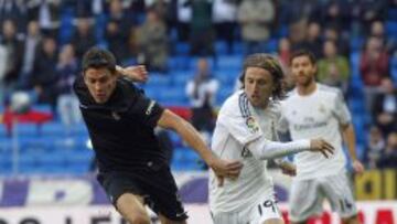 Elustondo, jugador de la Real Sociedad, cubre el balón ante la presión de Modric.