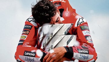 Marc Márquez se abraza a la torre de los campeones, trofeo del ganador de MotoGP.