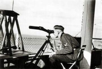 Un Obergefreiter alemán está sentado con miras ópticas en el balcón de una villa detrás del hotel Hermitage.
